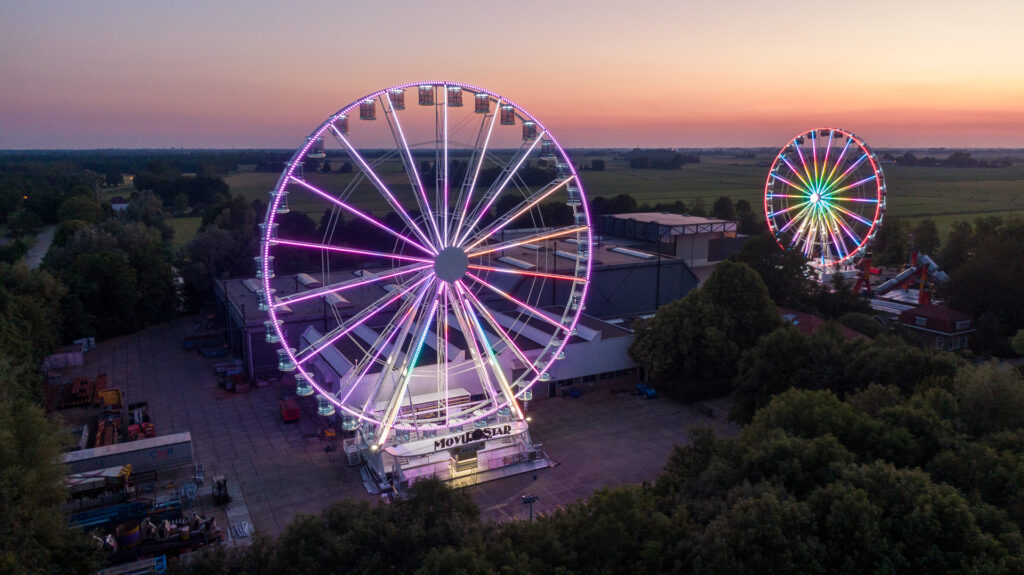 Verlichte reuzenraderen tijdens een kermisavond