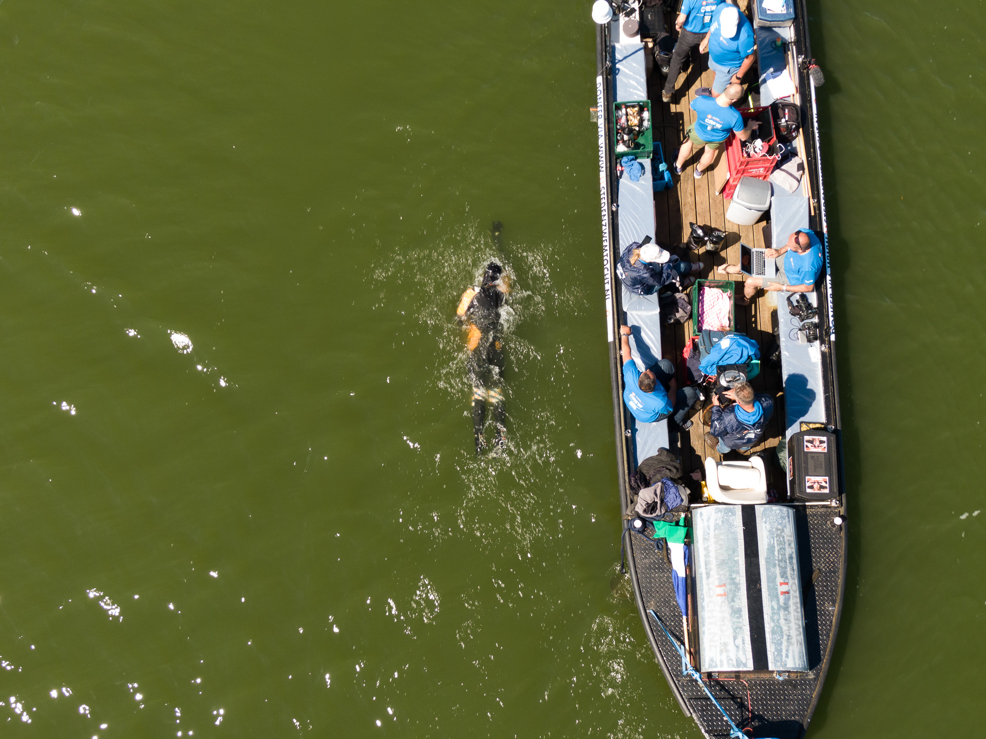 Een zwemmer met begeleiding op het water vanuit de lucht